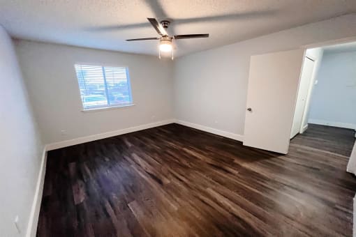 an empty living room with wooden floors and a ceiling fan at Northchase,Texas