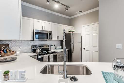 A kitchen with a stove, sink, and refrigerator at Rosemary Apartments, Texas