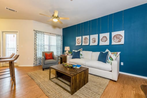 a living room with a white couch and a blue accent wall at Villa Espada Apartments, Texas, 78221