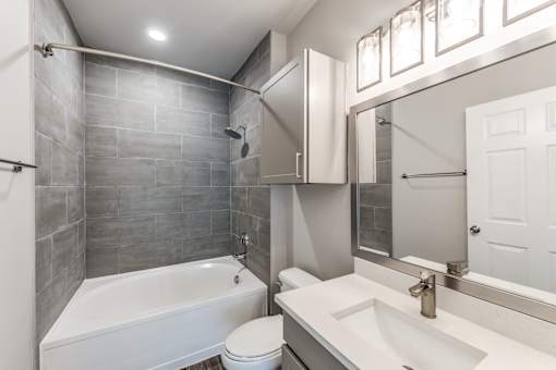 A bathroom with a white tub, sink, and toilet at Rosemary Apartments, Texas, 77384