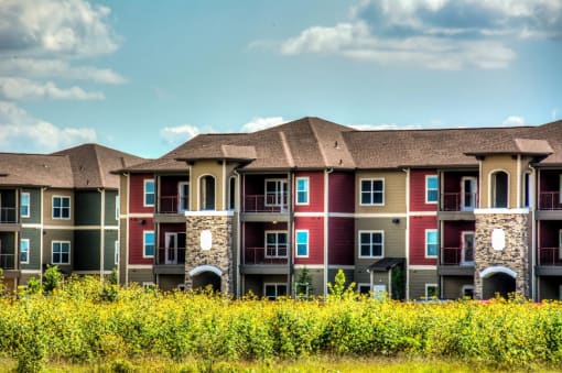 a row of apartment buildings with blue sky in the background at Villa Espada Apartments, San Antonio, TX