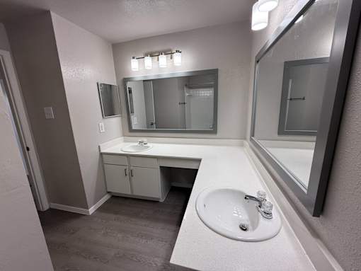A bathroom with a sink, mirror, and cabinet.