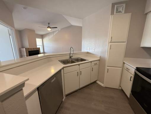 A kitchen with white cabinets and a black dishwasher.