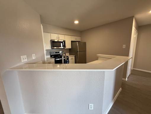 A kitchen with white cabinets and appliances.