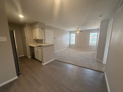 A kitchen with a refrigerator, sink, and cabinets.