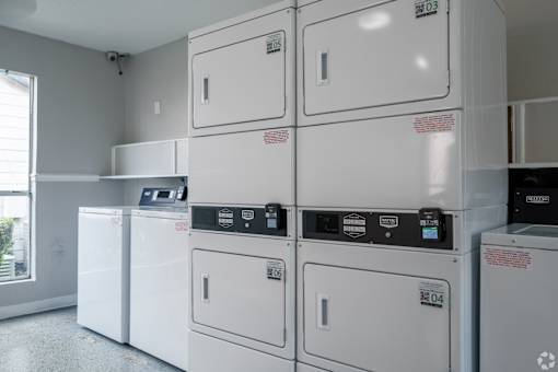 Row of white washing machines in a laundromat at Brook Meadow Village, Austin, Texas