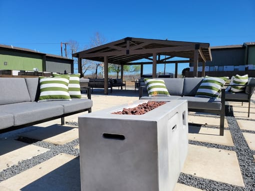 a fire pit on a patio with chairs and a gazebo at Ivy Plains at Brooks Apartments, San Antonio , 78223