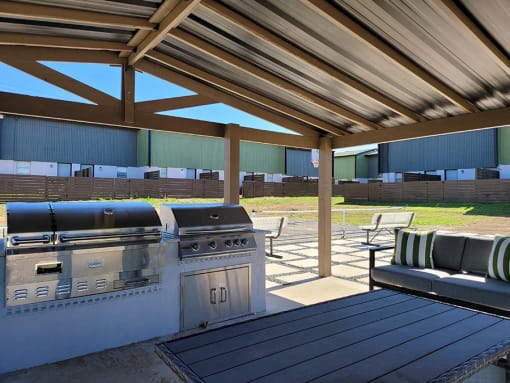 a patio with a grill and a table with chairs at Ivy Plains at Brooks Apartments, San Antonio