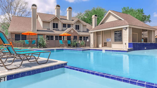 a swimming pool with chairs and a house in the background at Tranquility Grove, Texas 77090