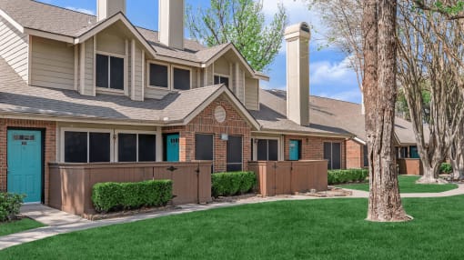 a house with a blue door and green grass at Tranquility Grove, Houston, Texas
