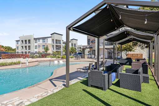 a pool with lounge chairs and awnings next to a swimming pool at Radius on Grove, Austin, TX, 78741
