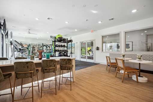 a living room with a bar and chairs and a dining room with tables at Radius on Grove, Austin, Texas