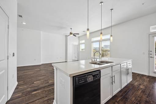 an open kitchen and living room with white walls and white counter tops and a sink at Radius on Grove, Austin, 78741