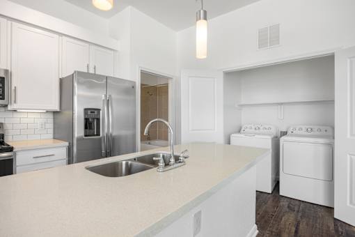 a white kitchen with stainless steel appliances and a white counter top at Radius on Grove, Austin