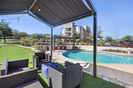 a backyard with a pool and patio with chairs and a canopy at Radius on Grove, Texas, 78741