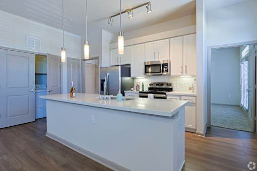 A kitchen with a white island and a refrigeratorat Radius on Grove, Austin, 78741