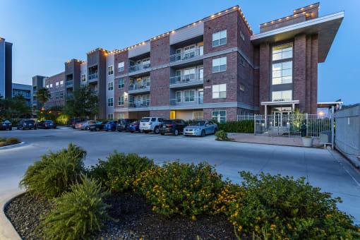 a large brick building with a parking lot in front of it at Republic at Alamo Heights, San Antonio, TX