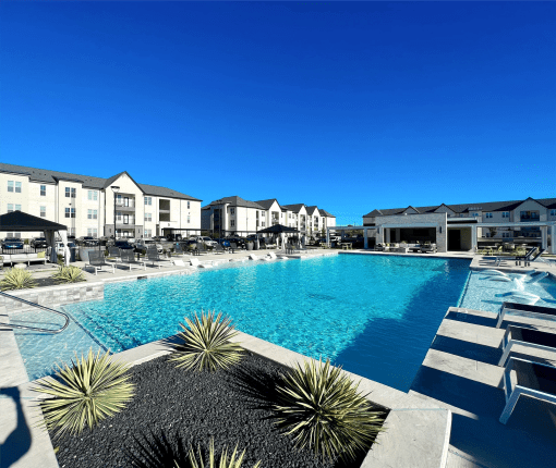 a large swimming pool with buildings in the background at The Fitzroy San Marcos, San Marcos, Texas