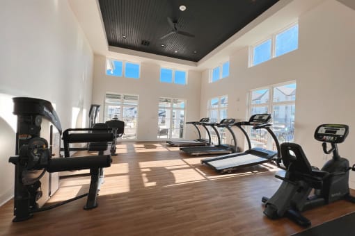 a gym with cardio equipment and windows in a building at The Fitzroy San Marcos, Texas