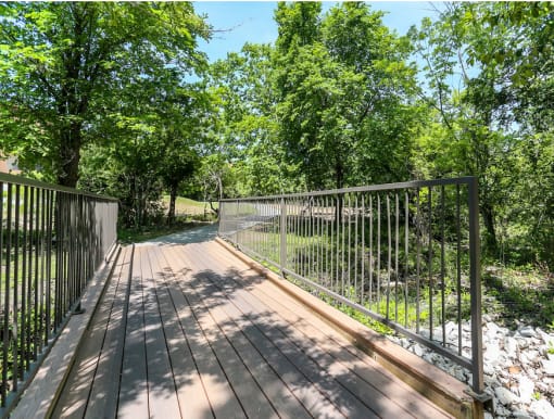 a wooden deck with a metal railing at Radius on Grove, Austin, 78741