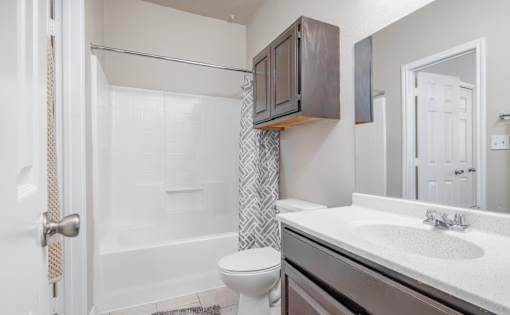 Modern bathroom with white countertop and dark cabinetry at Houston Street Townhomes Apartments, San Antonio, Texas