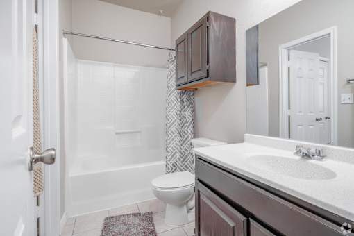 Modern bathroom with vanity and tub at Houston Street Townhomes Apartments, San Antonio