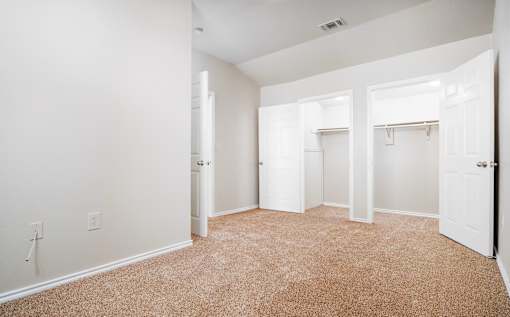 Spacious bedroom with dual walk-in closets at Houston Street Townhomes Apartments, San Antonio, Texas