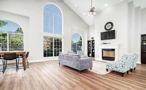 Spacious living room with vaulted ceiling and fireplace at Houston Street Townhomes Apartments, Texas