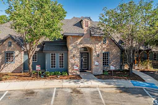 Stone and brick townhome exterior with archway entrance at Houston Street Townhomes Apartments, San Antonio, TX 78220