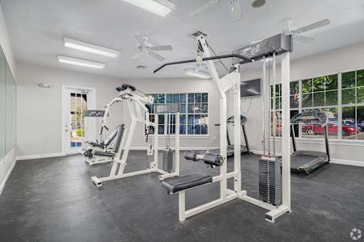 Fitness center with weight machines and cardio equipment at Houston Street Townhomes Apartments, San Antonio, Texas