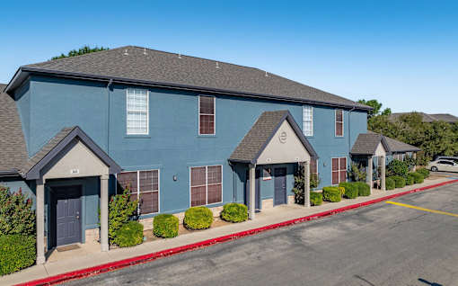 Two story townhome building exterior with gabled entryways at Houston Street Townhomes Apartments, San Antonio, 78220