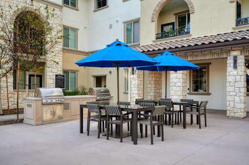 A blue umbrella is in front of a building.