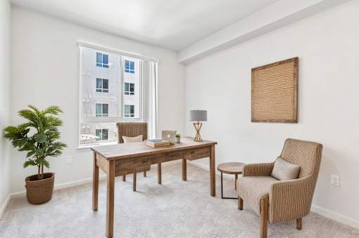 A room with a chair, table, and a potted plant.