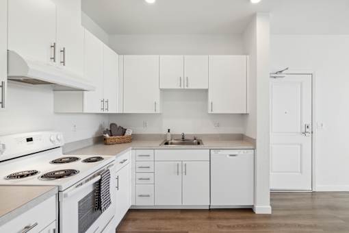 A white kitchen with an electric stove top & oven.