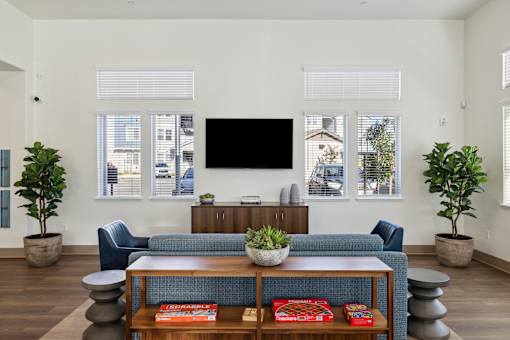 Clubhouse with a blue couch and a flat screen TV mounted on the wall.