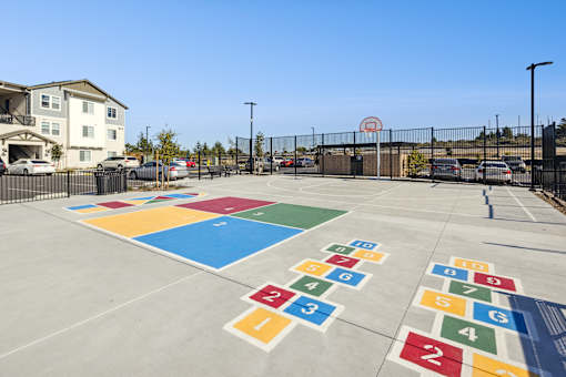 Recreation court with four square, a basketball hoop and hopscotch