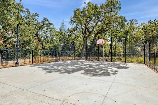 the basketball court is fenced in and has a basketball hoop on it