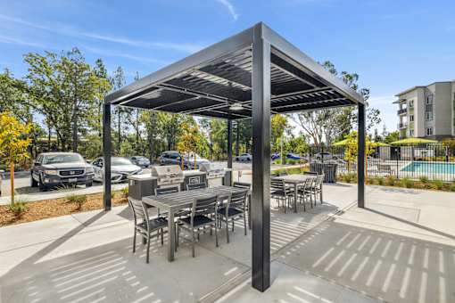 an outdoor patio with tables and chairs under awning