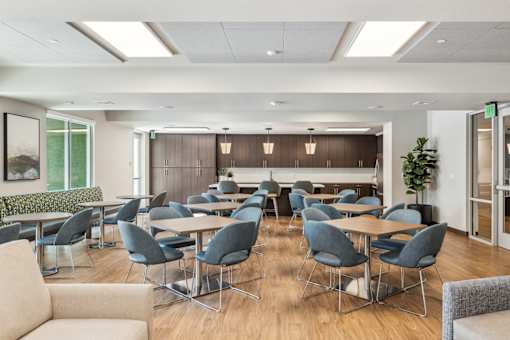 a conference room with tables and chairs and a kitchen