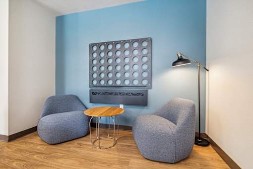 a room with two chairs and a table and a painting on the wall
