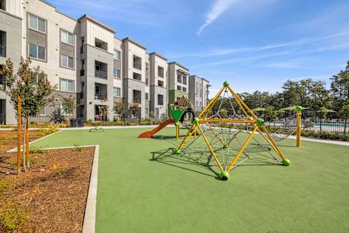 the preserve at ballantyne commons park playground with swing set and building with apartments
