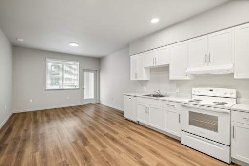 an empty kitchen with white appliances and white cabinets