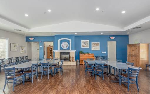 A large dining room with a fireplace and blue walls.