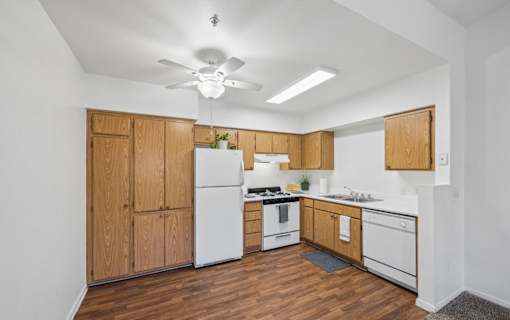 A kitchen with wooden cabinets and white appliances.