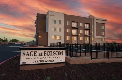 a sign in front of Sage at Folsom with a sunset in the background