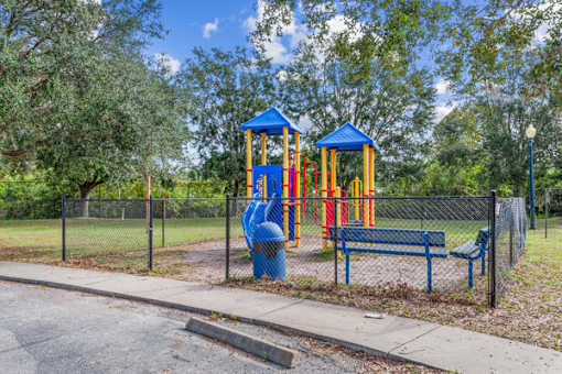 A playground with a blue slide and a blue bench.