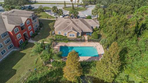 A bird's eye view of a residential area with a swimming pool.