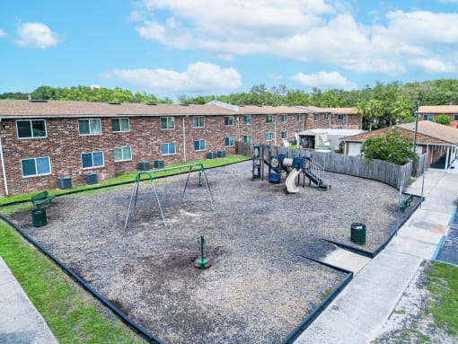 an empty playground in front of a brick building