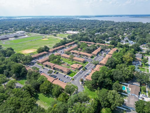 an aerial view of a city with trees and a body of water
