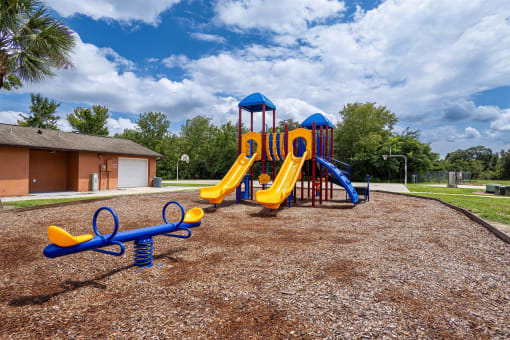 a playground at a park with a yellow and blue playset